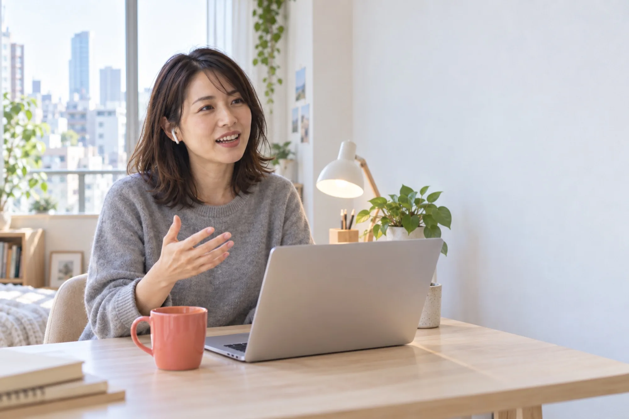 朝の部屋で、ノートパソコンに向かって英語で話す女性（写真は見本）